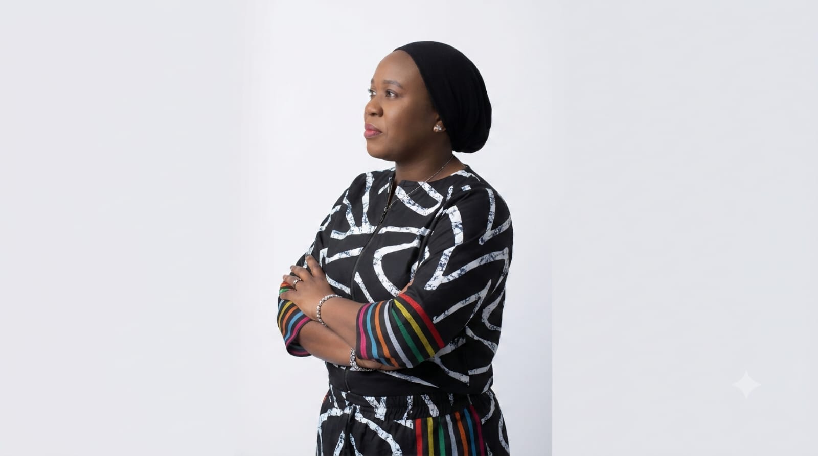 Bimpe Bakare standing with arms folded, wearing a black and white patterned outfit